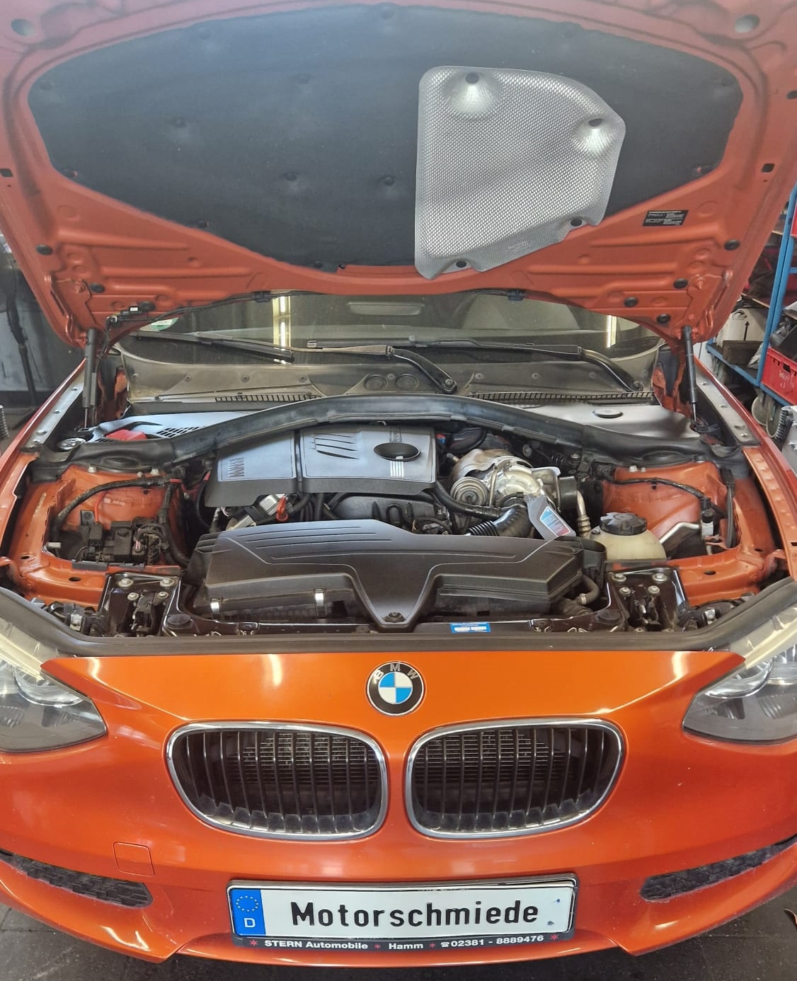 BMW 116i F20 N13B16 - Fahrzeug von vorne mit geöffneter Motorhaube bei Motorschmiede